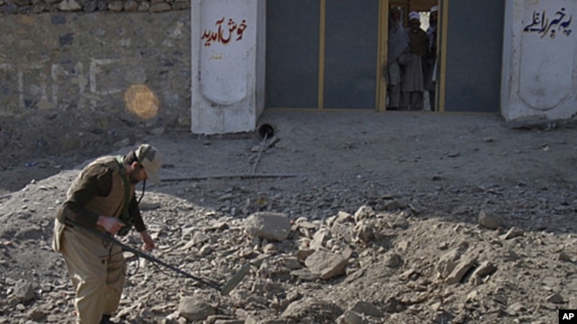 A paramilitary soldier uses a metal detector to survey the site of a bomb attack in Landi Kotal, in northwest Pakistan, December 31, 2011.