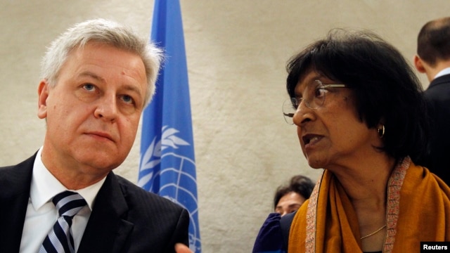 U.N. High Commissioner for Human Rights Navi Pillay (R) talks to Remigiusz Henczel, President of the Human Rights Council before the 22nd session of the Human Rights Council at the United Nations in Geneva Feb. 25, 2013.