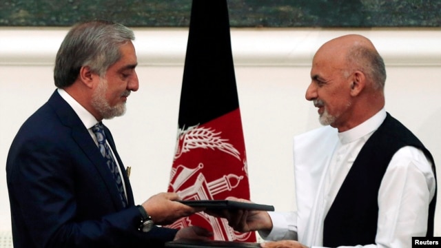 Abdullah Abdullah (izquierda) y Ashraf Ghani intercambian los protocolos firmados tras el acuerdo de gobierno de unidad nacional.