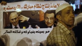 With a sign that reads 'No to restoring the former Mubarak regime,' in the background, protesters demonstrate against the results of the first round of Egypt's presidential elections at Tahrir Square in Cairo June 1, 2012. 