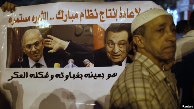 With a sign that reads 'No to restoring the former Mubarak regime,' in the background, protesters demonstrate against the results of the first round of Egypt's presidential elections at Tahrir Square in Cairo June 1, 2012. 