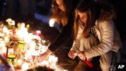 Visitors light candles at a memorial to shooting victims, Monday, Dec. 17, 2012, in Newtown, Conn.