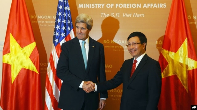 Ngoại trưởng Mỹ John Kerry bắt tay với Bộ trưởng Ngoại giao Việt Nam Phạm Bình Minh trong chuyến thăm Việt Nam của ông Kerry tháng 12 năm 2013. 