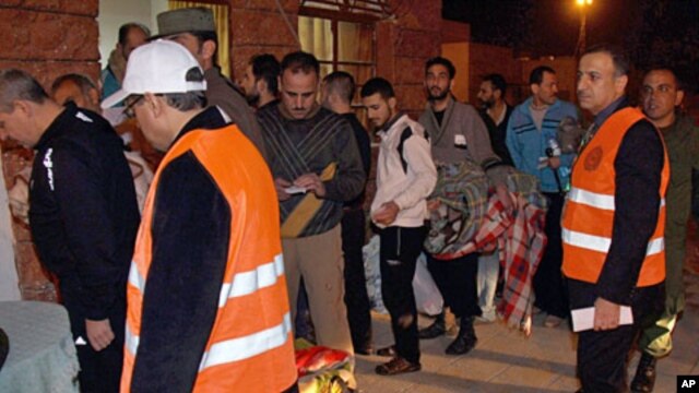 Arab league observers wearing orange vests oversee the releasing of Syrian prisoners who wait in queue to be released from Adra Prison on the outskirts of Damascus,  January 15, 2012
