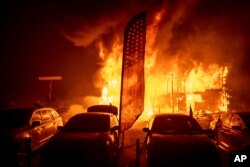 Las llamas consumen un concesionario de automóviles mientras el Camp Fire arrasa a su paso por Paradise, California, el jueves 8 de noviembre de 2018.