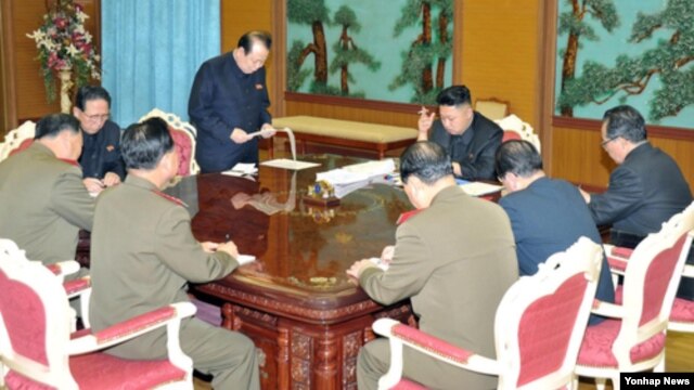 국가안전 및 대외부문 일꾼협의회를 주재하고 있는 김정은 북한 국방위원회 제1위원장(정면 오른쪽). 김정은 국방위원회 제1위원장부터 시계방향으로 김계관 내각 외무성 제1부상, 김영일 당 국제비서, 김원홍 국가안전보위부장, 최룡해 군 총정치국장, 현영철 군 참모총장, 홍승무 당 부부장, 박도춘 노동당 군수담당비서. 조선중앙통신 공개. 