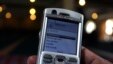 A man scrolls through his mobile phone to carry out a money transaction via M-PESA in Nairobi, Kenya.