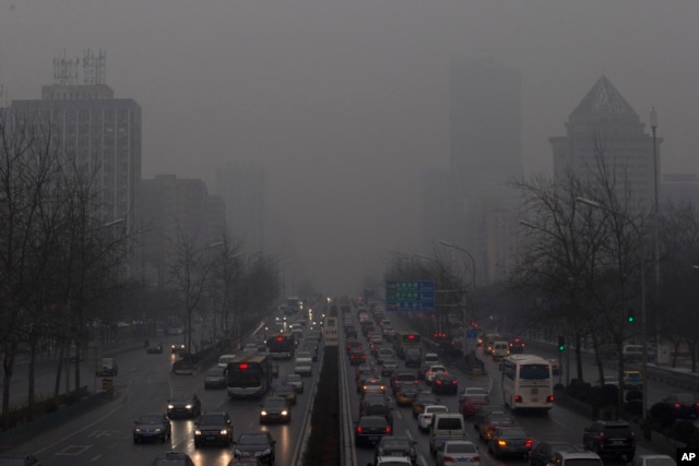 Dòng xe ô-tô di chuyển chậm chạp trong bóng tối của sương mù dày đặc bao trùm thủ đô Bắc Kinh, ngày 31/1/2013.