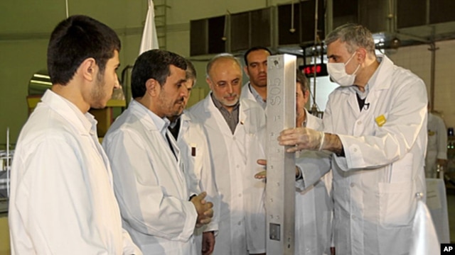 This photo released by the Iranian President's Office, claims to show Iranian President Mahmoud Ahmadinejad, second left being escorted by technicians during a tour of Tehran's research reactor center in northern Tehran, Iran, February 15, 2012.
