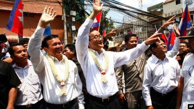 Cambodia's opposition leader Sam Rainsy, center, of the Cambodia National Rescue Party waves along with his party Vice President Kem Sokha, third from left, during a march in Phnom Penh, file photo. 