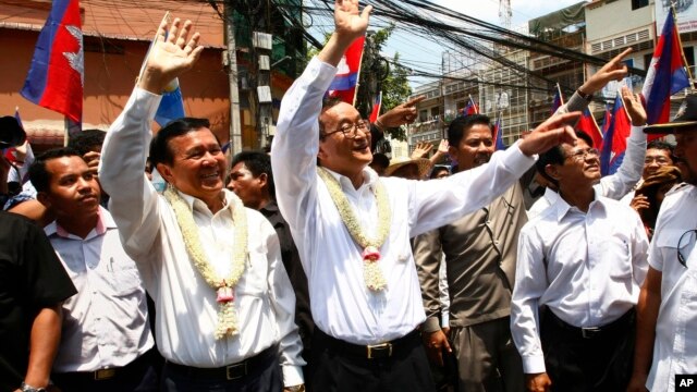 Cambodia's opposition leader Sam Rainsy, center, of the Cambodia National Rescue Party waves along with his party Vice President Kem Sokha, third from left, during a march in Phnom Penh, Cambodia, file photo. 