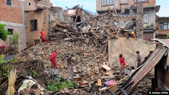 A family searches for any valuables they can find in their destroyed home, Sankhu, Nepal, April 29, 2015. (Photo: R. Kalden for VOA)