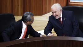 Jose Alejandro Luna Ramos (R), president of the Federal Electoral Tribunal (TRIFE), talks to magistrate Flavio Galvan during a public session in Mexico City August 31, 2012. Mexico's electoral tribunal officially named Enrique Pena Nieto as president-elec