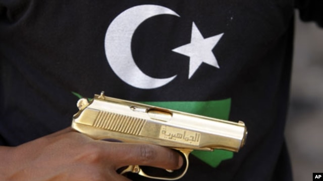 A Libyan National Transitional Council (NTC) fighter holds a golden gun, marked in Arabic al-Jamahiyra (Gadhafi's people's republic)  (File)