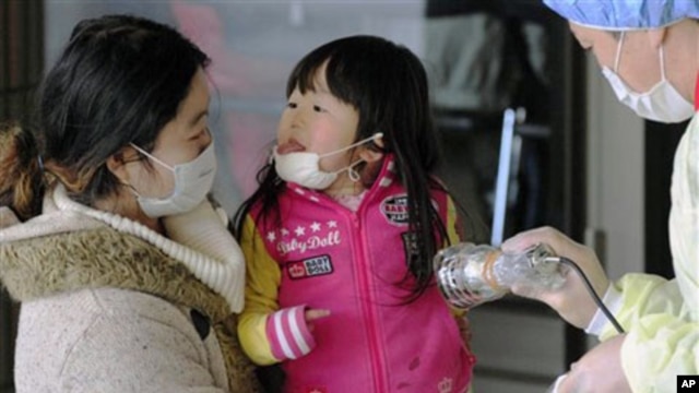Mother and daughter receive radiation exposure scanning in Fukushima, northern Japan Friday, one week after a massive earthquake and tsunami, March 18, 2011