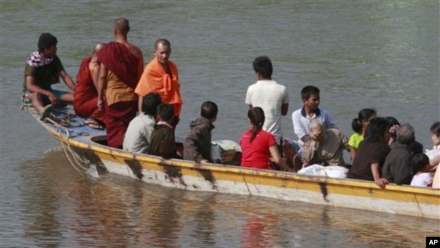 A boat carrying last batch of Burmese refugees back home cruises on the Moei river in Mae Sot, Thailand, 10 Nov 2010