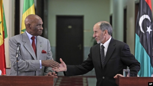 Senegal's President Abdoulaye Wade, left, shakes hands with National Transitional Council chairman Mustafa Abdul-Jalil after their joint press conference in Benghazi, Libya, June 9, 2011