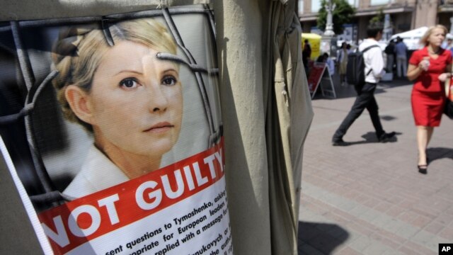 People walk past a tent camp in support of former Ukrainian Prime Minister Yulia Tymoshenko in Kiev, July 20, 2012.