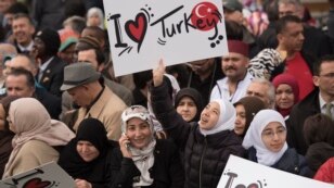 Crowd members hold signs showing support for Turkish President Recep Tayyip Erdogan at the inauguration of the Diyanet Center of America in Lanham, Maryland, April 2, 2016.