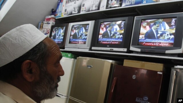 A man watches Pakistan's Prime Minister Yusuf Raza Gilani on a televised address to the parliament at an appliance store in Islamabad on May 9, 2011.
