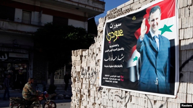 FILE - A man on a motorcycle rides past a poster depicting Syria's President Bashar al-Assad on a wall in the pro-government al-Zahraa neighbourhood in Homs, May 15, 2014.