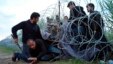 Migranti prolaze ispod žičane ograde na granici Mađarske i Srbije