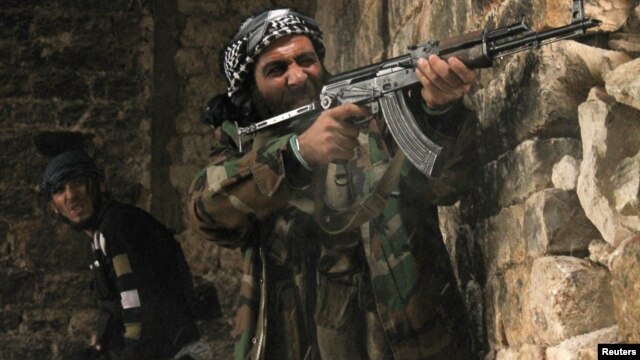 Un rebelde sirio dispara contra posiciones gubernamentales en Qastal Harami, en Aleppo, donde el grupo terrorista al-Nusra amenaza con robarse la revolución.