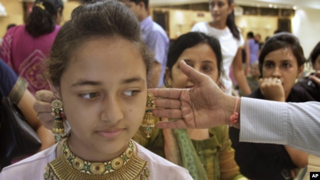 People shop for gold jewelry in Ahmadabad, India, May 6, 2011, during the Hindu festival " Akshay Tritiya", which is considered auspicious for buying gold. Indian-Americans' love affair with gold has made them targets for criminals.