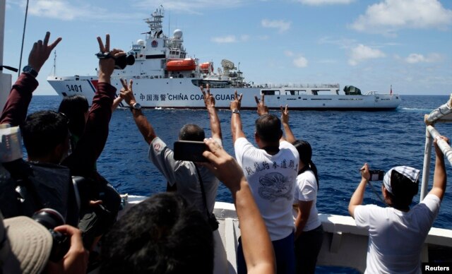 FILE - A Chinese Coast Guard vessel maneuvers to block a Philippine government supply ship with members of the media aboard at the disputed Second Thomas Shoal, part of the Spratly Islands, in the South China Sea.