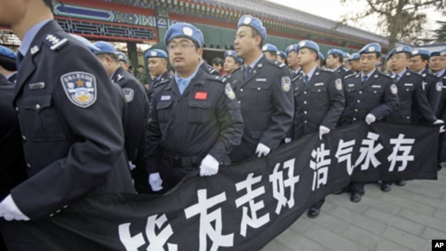 Members of China's peacekeeping police contingent, who have been to Haiti, hold a banner as they wait in line to attend a funeral for eight Chinese peacekeepers killed in the Haiti earthquake, at Babaoshan Revolutionary Cemetery in Beijing, January 20, 20