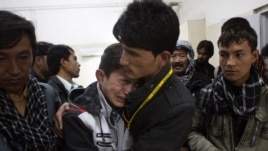 A Pakistani man comforts another mourning for a family member who died in a bomb blast, at local hospital in Quetta, Pakistan on Feb. 16, 2013.