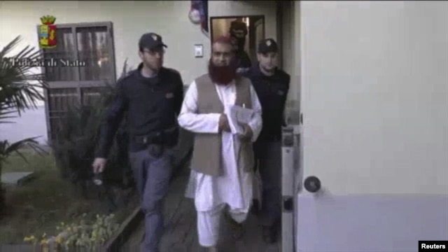 Un policía italiano escolta a un sospechoso de formar parte de un grupo terrorista inspirado por al-Qaeda.