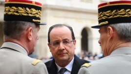 France's President Francois Hollande (C) speaks to military officials as he attends a ceremony to the memory of Stephane Hessel, at the Invalides in Paris, March 7, 2013.