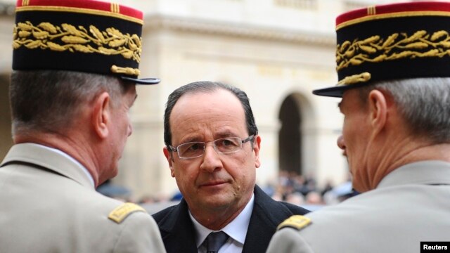 France's President Francois Hollande (C) speaks to military officials as he attends a ceremony to the memory of Stephane Hessel, at the Invalides in Paris, March 7, 2013.