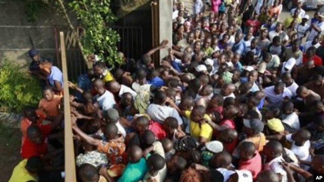 Voters, angry at polls not opening one hour after their scheduled start, break down a gate at Groupe Scolaire Saint Jeanne in the Abobo neighborhood of Abidjan, Ivory Coast, 28 Nov 2010