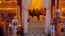 Cambodian King Norodom Sihamoni, facing camera on right in background, son of the late King Norodom Sihanouk, and his mother, Queen Norodom Monineath, behind him, pray inside the crematorium where the body of Sihanouk rests in Phnom Penh, Cambodia, Monday, Feb. 4, 2013. Hundreds of thousands of mourners gathered in Cambodia's capital Monday for the cremation of Sihanouk, the revered "King-Father," who survived wars and the murderous Khmer Rouge regime to hold center stage in the Southeast Asian nation for more than half a century. (AP Photo/David Guttenfelder)