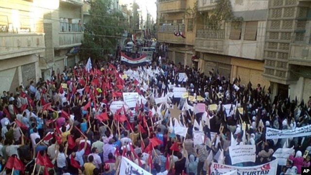 Demonstrators march through the streets in Homs.  Britain, France, Germany and Portugal Tuesday circulated a new draft U.N. resolution condemning Syria that drops previous calls for immediate sanctions against Damascus, September 27, 2011.