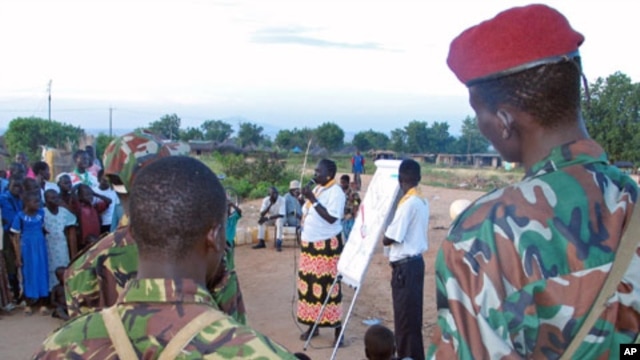 A Sudanese aid worker [C] talks to Sudanese soldiers and scouts on how to spread the message on HIV/AIDS at an internally displaced camp in Juba, southern Sudan, October 2005. (file photo)