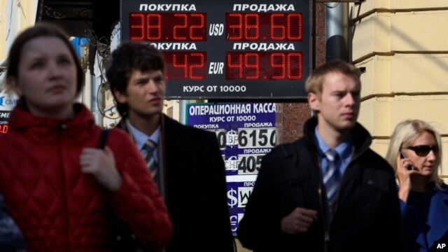 Cư dân đi bộ qua quầy đổi tiền ở Moscow. Đồng rúp của Nga tiếp tục mất giá so với đồng Euro và Đôla.