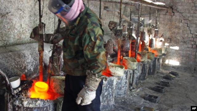 Ren Limin, a worker at the Jinyuan Company's smelting workshop, prepares to pour the rare earth metal Lanthanum into a mold near the town of Damao in China's Inner Mongolia Autonomous Region Oct. 31, 2010.
