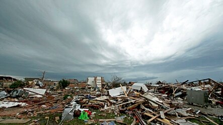 Storm clouds build in the distance beyond tornado-ravaged homes in Moore, Oklahoma, May 21, 2013. 