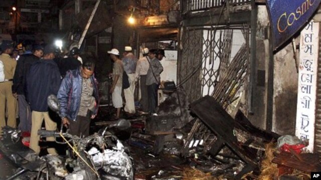 Policemen inspect the site of a bomb explosion at Zaveri bazaar in Mumbai, India, July 13, 2011