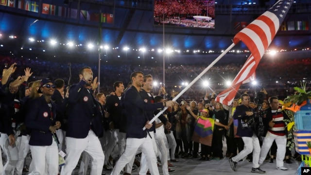 Multi-gold medal winner in swimming Michael Phelps carries the flag of the United States as he leads the U.S. team during the opening ceremony for the 2016 Summer Olympics in Rio de Janeiro, Brazil, Aug. 5, 2016.