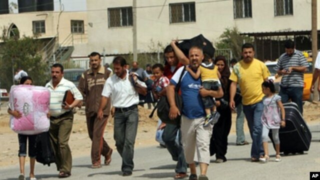 Palestinians carry their belongings as they head towards the newly-opened border crossing to Egypt in Rafah, in the southern Gaza Strip, 01 Jun, 2010