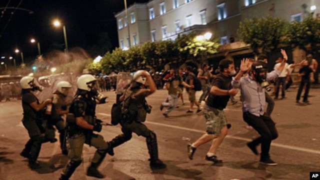 Greek riot police officers charge protesters at Syntagma square in front of the Greek Parliament in central Athens, during minor scuffles following a peaceful ongoing rally against plans for new austerity measures,  June 22, 2011