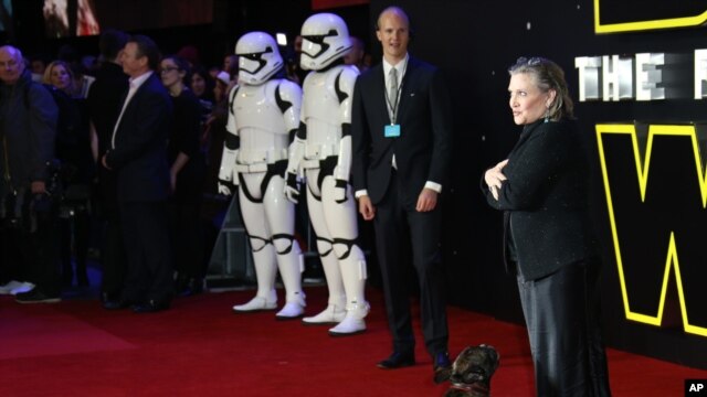 Carrie Fisher poses for photographers with a dog upon arrival at the European premiere of the film 'Star Wars: The Force Awakens' in London, Dec. 16, 2015. (Photo by Joel Ryan/Invision/AP)