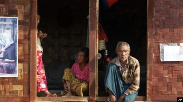 Ethnic Kachin people sit in the doorways of shelters at a temporary camp for people displaced by fighting between government troops and the Kachin Independence Army, or KIA, outside the city of Myitkyina in the north of the country, February 22, 2012. 
