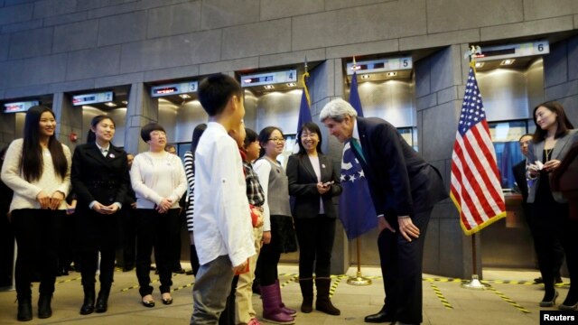 Ngoại trưởng Hoa Kỳ John Kerry (thứ ba từ phải sang) trò chuyện với một trong bốn em học sinh trong buổi lễ trở thành những công dân Trung Quốc đầu tiên được cấp visa Mỹ 10 năm tại đại sứ quán Hoa Kỳ ở Bắc Kinh, 12/11/2014.