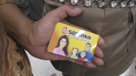 A woman in Mexico City shows her pre-paid gift card which several people say were given them by the party that won Mexico's presidency, (Jul 3, 2012 photo)