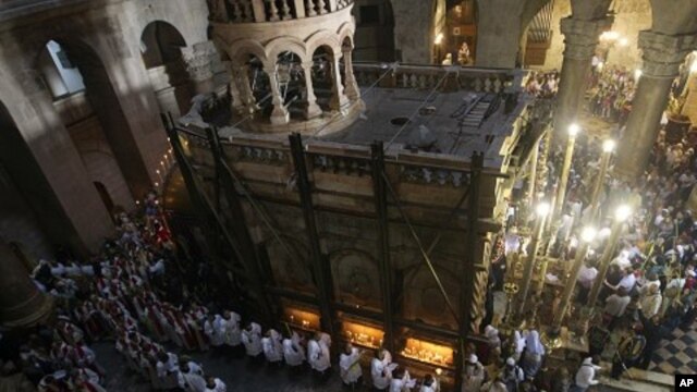 Catholic clergy carry palm fronds during the Palm Sunday procession in the Church of the Holy Sepulcher in Jerusalem's Old City, April 17, 2011